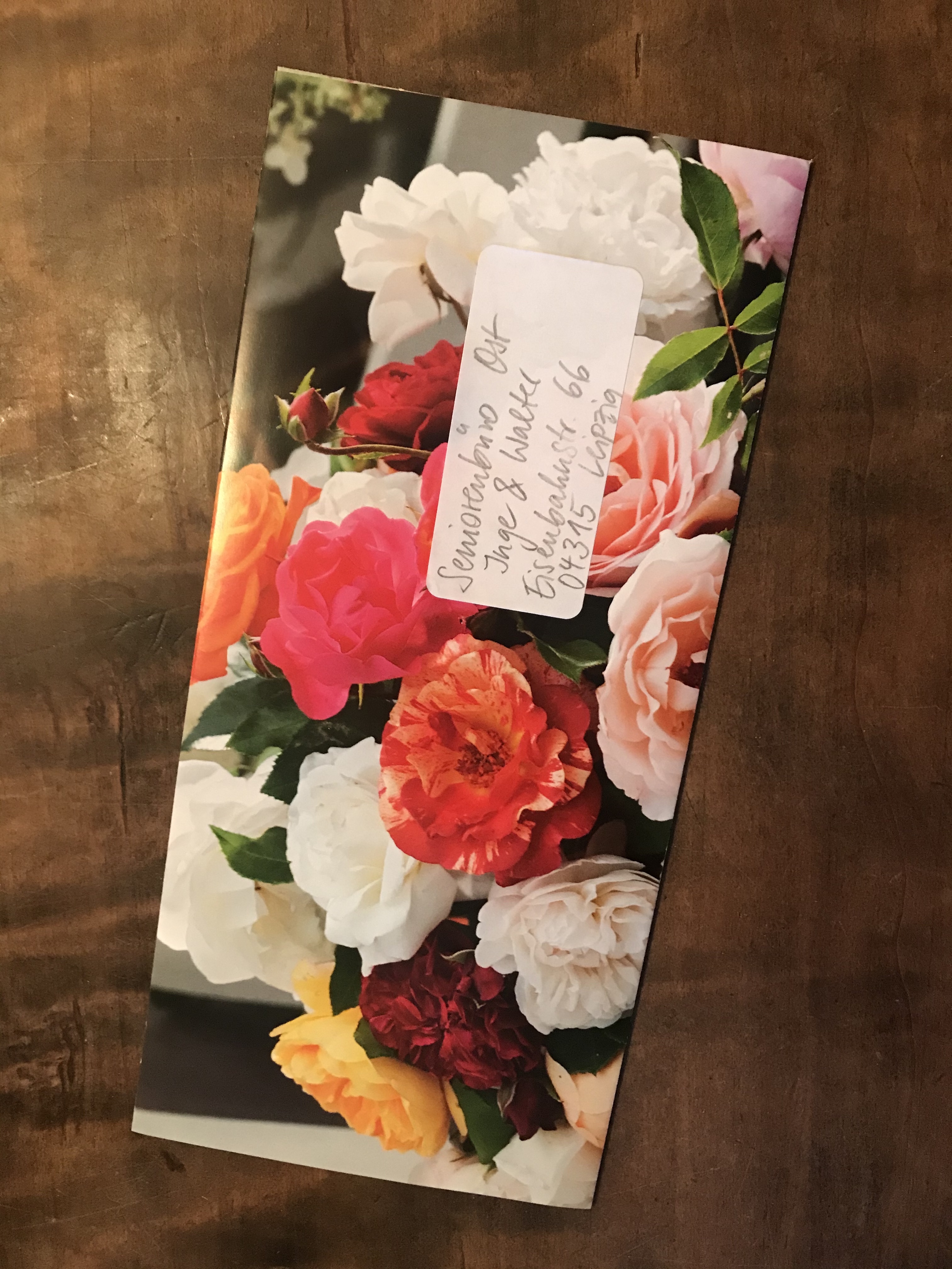 Ein Umschlag im Format DIN lang wurde aus einem Rosen-Foto gefaltet. Er ist an das Seniorenbüro Ost in Leipzig adressiert.